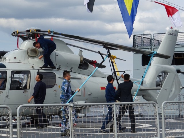 Die Besatzung der Binzhou bereitet den Bordhubschrauber Harbin Z-9 auf das Verfahren in den Hangar vor. Auf Spielereien wie eine vollautomatische Verfahranlage wurde anscheinend verzichtet. Muskelschmalz war angesagt